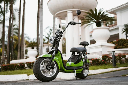 Small Green Moped Standing Outdoors