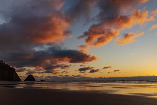 Stunning beach sunset featuring vibrant clouds and a tranquil ocean view.