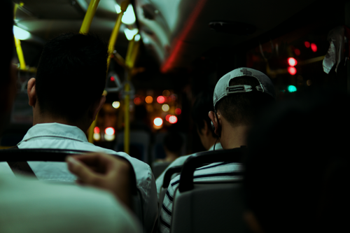 Free Passengers seated inside a dimly lit city bus during a night commute, capturing urban life. Stock Photo