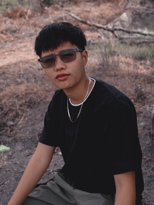 Free Casual portrait of a young man wearing sunglasses sitting outdoors in natural surroundings. Stock Photo