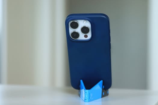 A blue smartphone featuring a triplet camera lens resting on a blue stand, captured in Sweden.