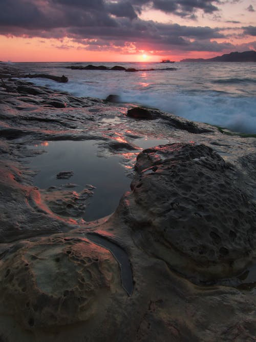 Gray and Black Rock Formation Near the Ocean during Sunset