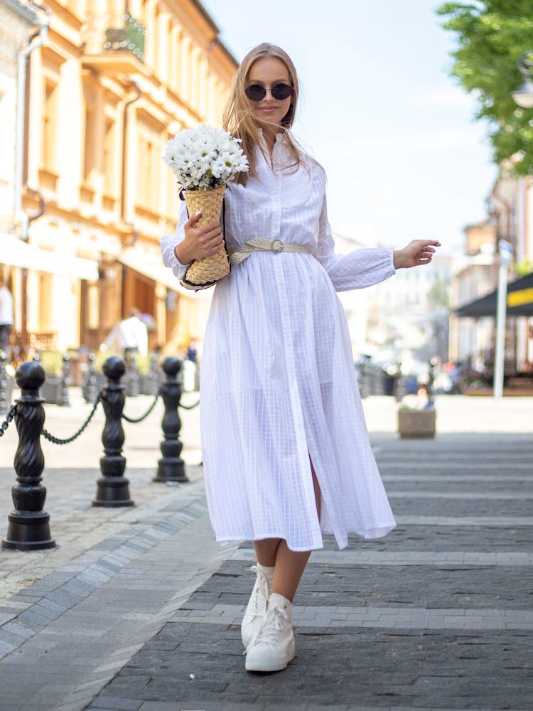 Woman In Dress Posing With Flowers On Street