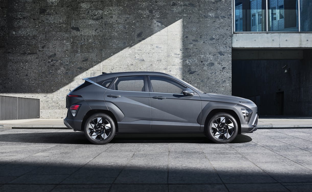 A side view of the Hyundai Kona parked in front of a building · Free ...