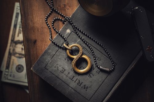 Free Stylish brass octopus pendant over a vintage book with scattered currency. Stock Photo