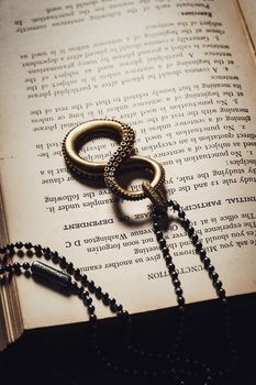 Elegant jewelry piece resembling an octopus lays on an open book, blending literature and fashion.