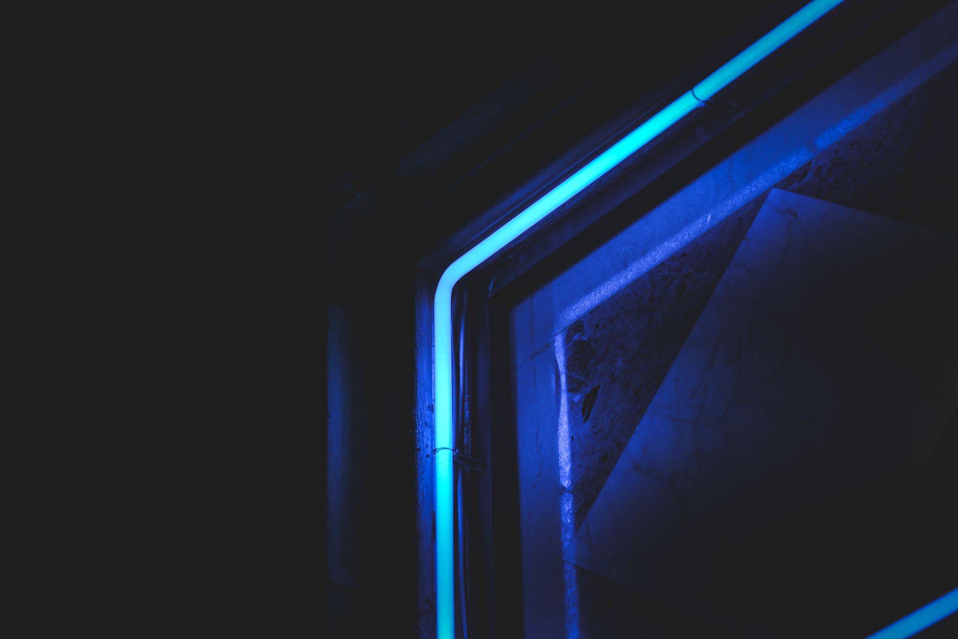 Abstract close-up of neon blue light in dark setting, highlighting modern artistic design.