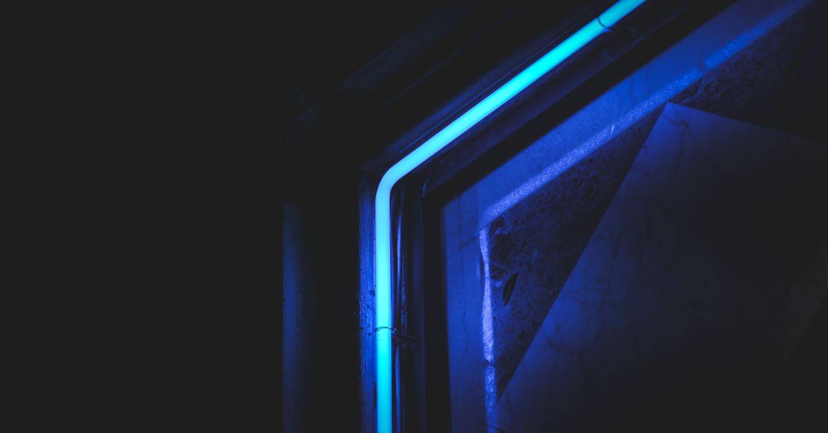Abstract close-up of neon blue light in dark setting, highlighting modern artistic design.