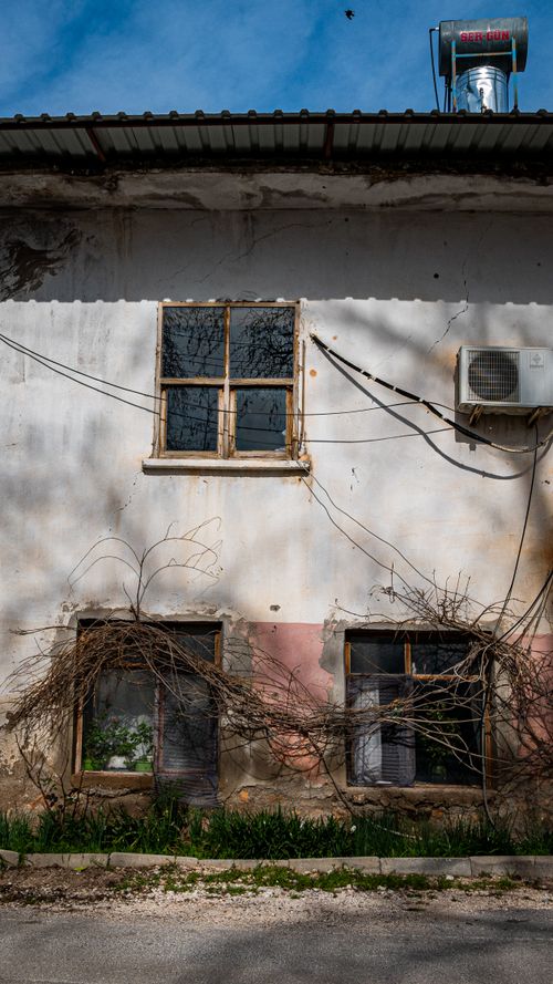 Free Vintage facade with ivy, windows, and air conditioning unit on a sunny day. Stock Photo