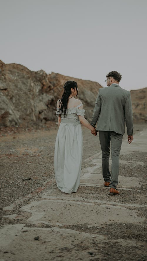 Couple Walk on Stones against Rocks