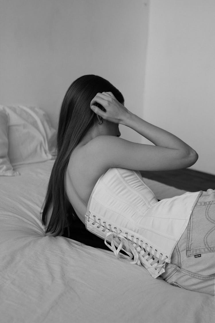 Young Brunette Wearing A Corset Lying On A Mattress