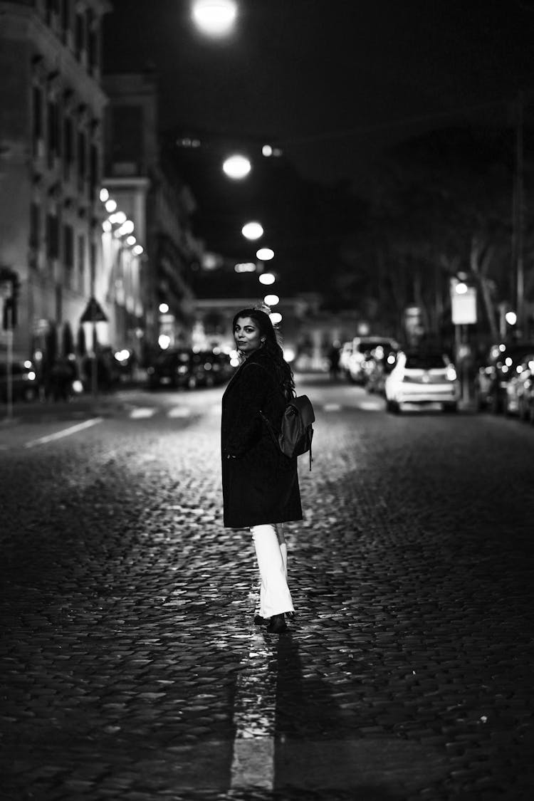 Young Woman Standing In The City Street At Night 