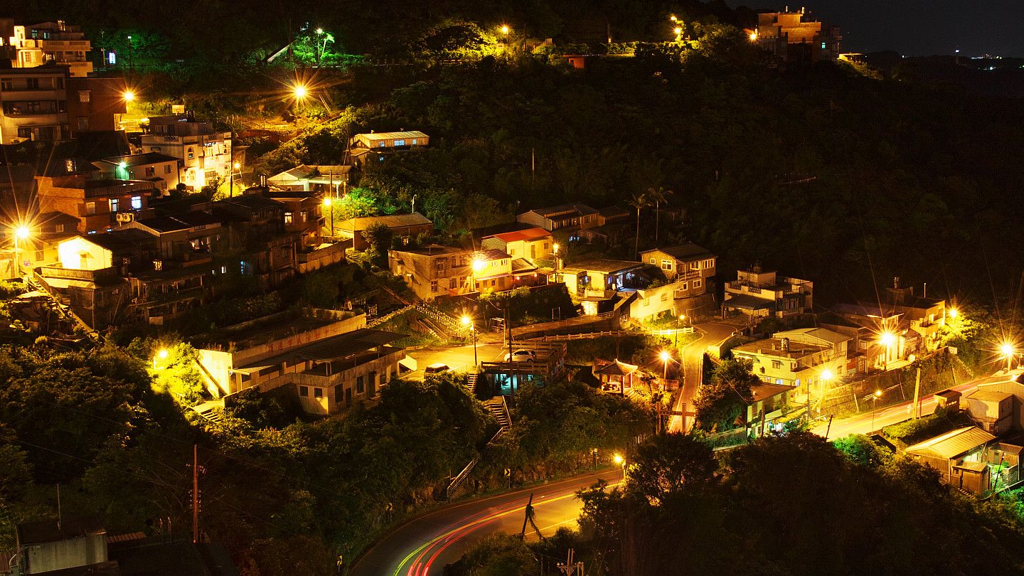 Evening hillside village illuminated by street lights