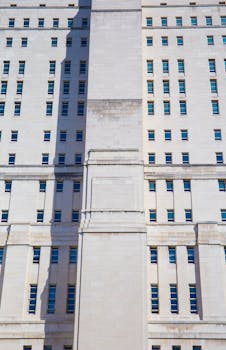Vertical view of Senate House's art deco architecture in London, accentuated by sunlight.