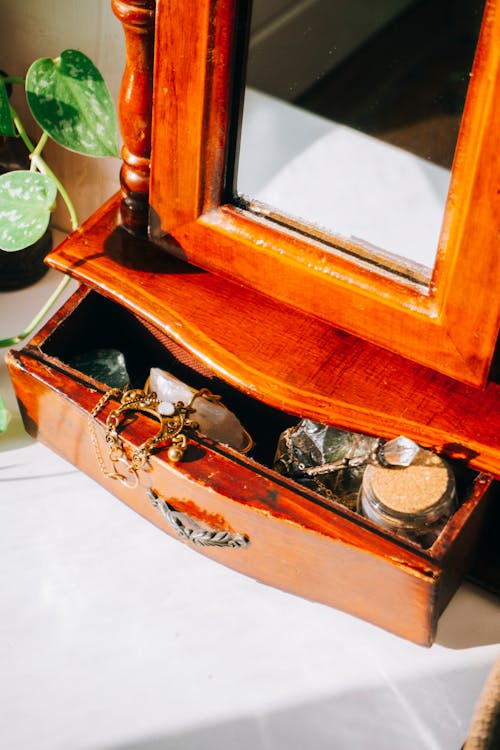 Jewelry in a Wooden Drawer under a Mirror 