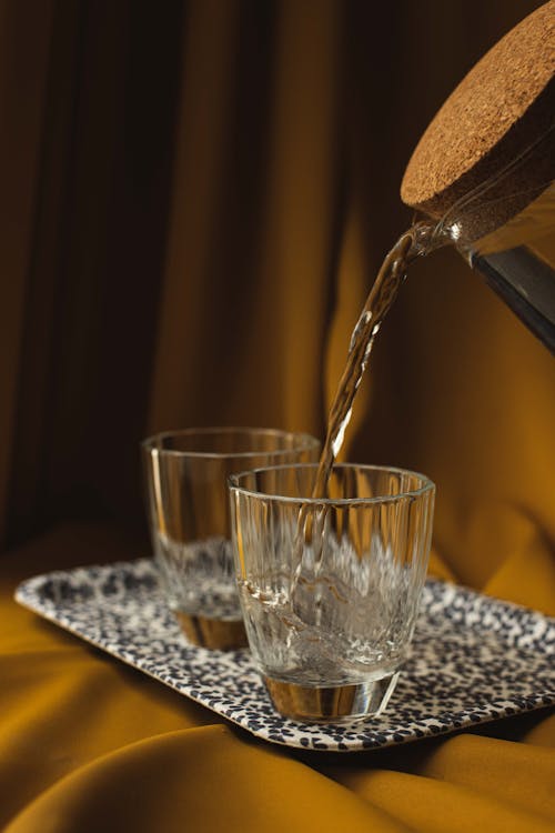 Pouring Water into Glasses on Tray
