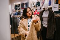 Woman Checking Price Near Mannequin