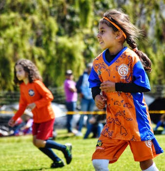 Energetic young girls playing soccer on a sunny day, showcasing fun and teamwork.