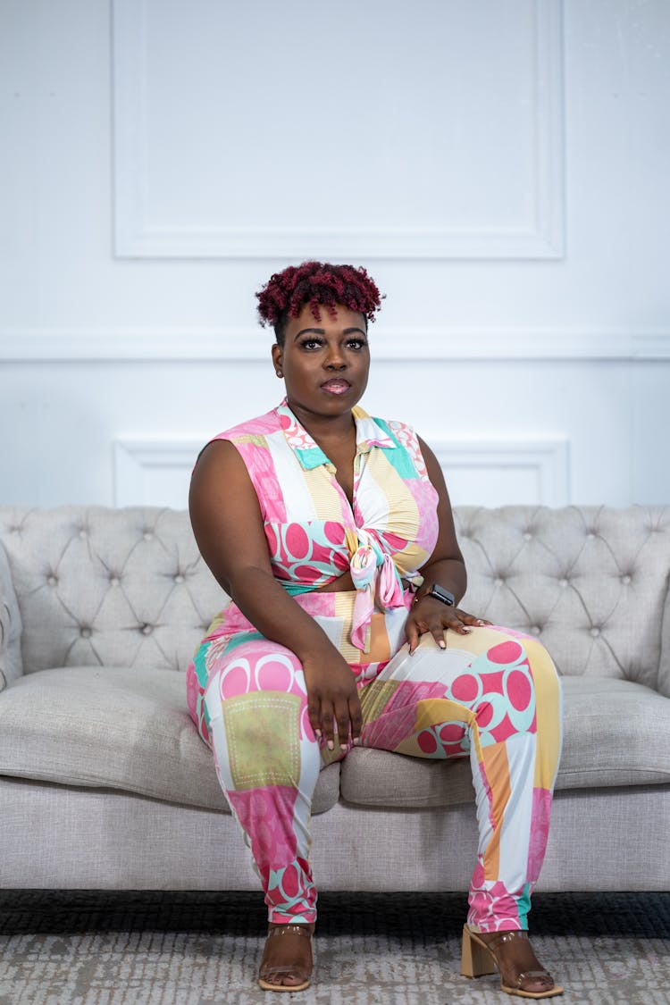 Stylish Overweight Woman In Colorful Costume Sitting On Couch