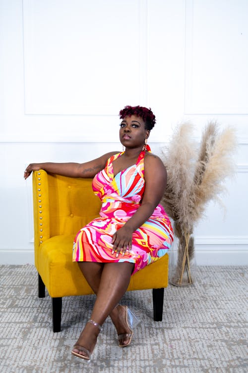 Woman in a Colorful Dress Sitting in an Armchair 