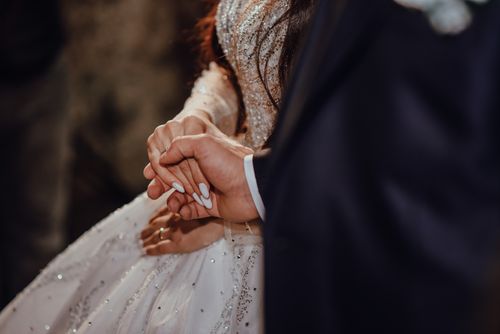 Free A close-up image capturing a bride and groom holding hands during their wedding ceremony. Stock Photo