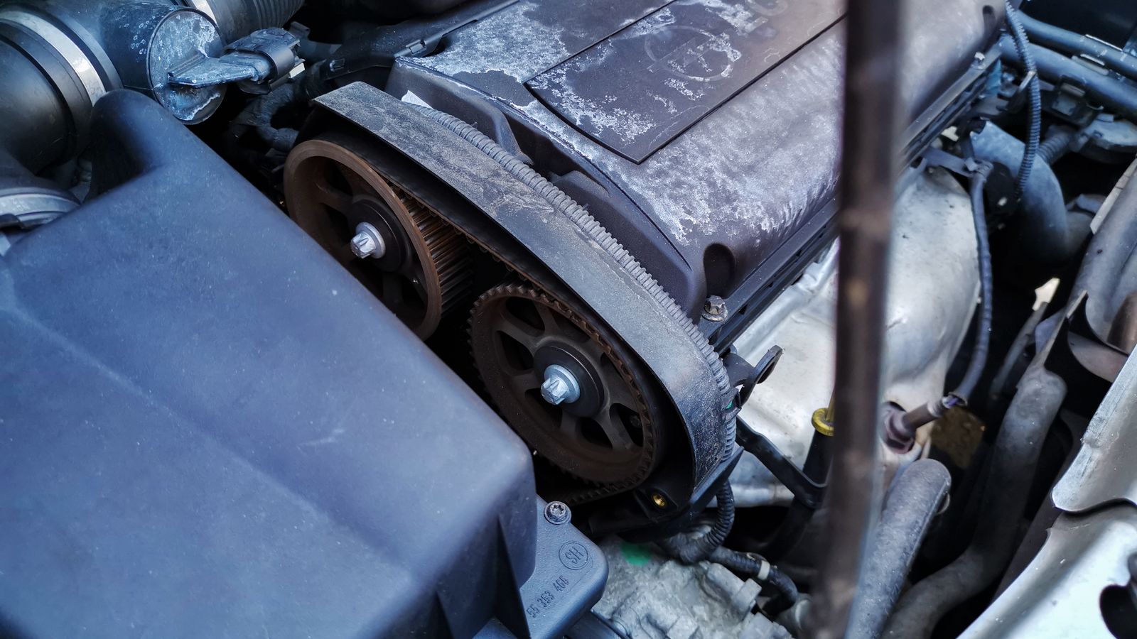 Detalhe da correia de acessórios, polias e tensor no cofre de um carro usado