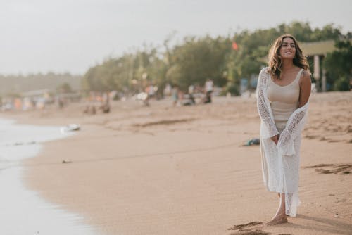 Young Woman Standing on a Beach and Smiling 