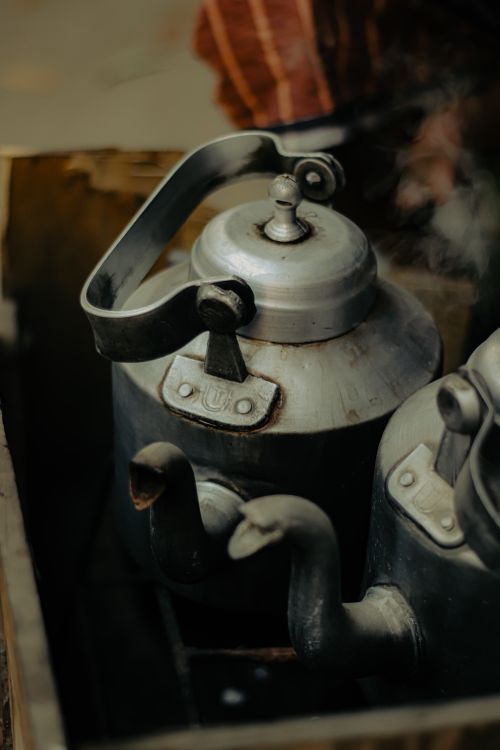 Free Close-up of vintage metal kettles steaming outdoors in a Dhaka market. Stock Photo