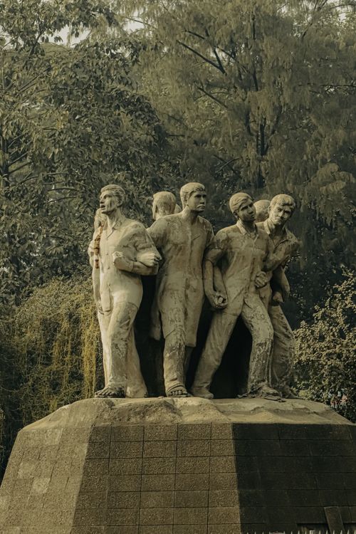 Free A powerful stone sculpture depicting multiple figures, surrounded by lush greenery in Dhaka, Bangladesh. Stock Photo
