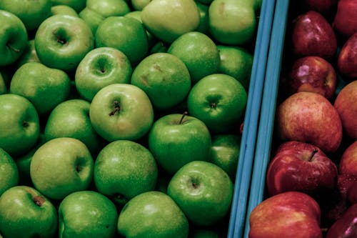 Close-up of Green and Red Apples in Container in a Market 