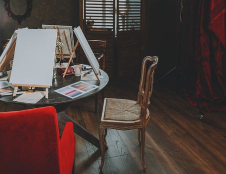 A cozy indoor art studio setup with blank canvases on easels, ready for a painting class.