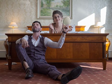 A stylish couple enjoying a relaxed moment in a luxurious hotel suite, showcasing love and intimacy.