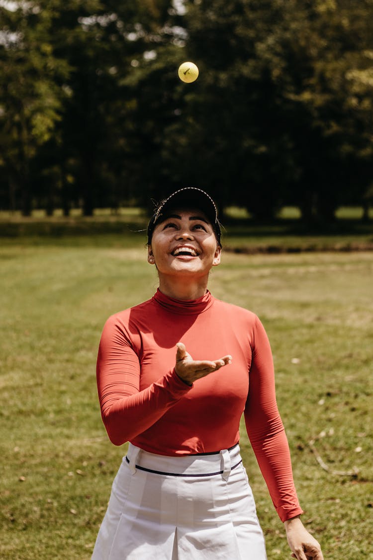 Woman Throwing Ball In Park