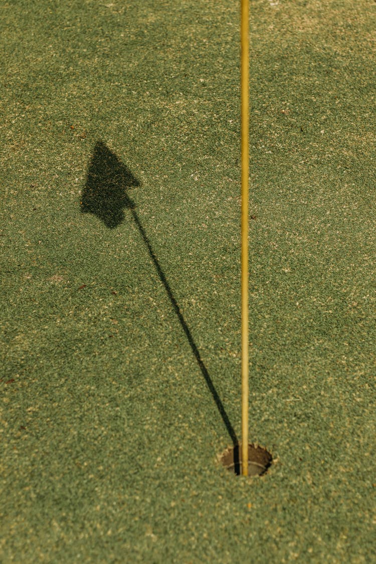 Flagstick Shadow On Golf Course Lawn