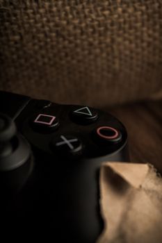 Detailed view of a gaming controller with iconic symbols on burlap background.