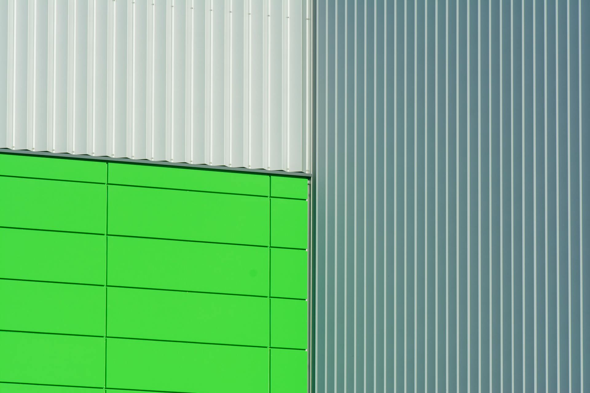 Close-up of a geometric industrial wall with green and aluminum textures.