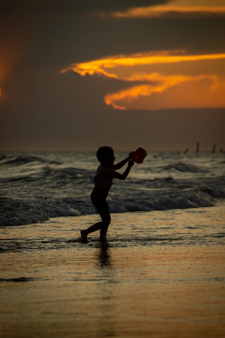 Photo Of A Boy Playing On A Beach In The Dawn