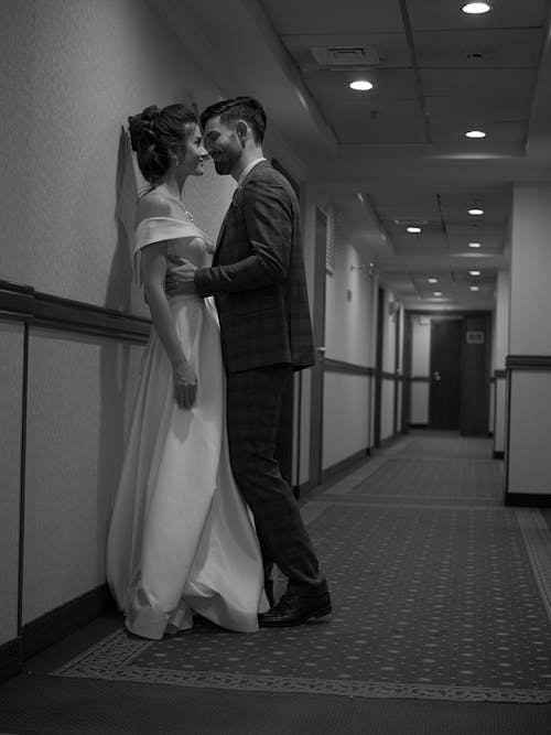 Newlyweds Standing Together in Corridor in Black and White