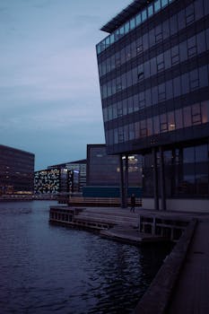 Evening view of modern office buildings along a waterfront in Copenhagen.