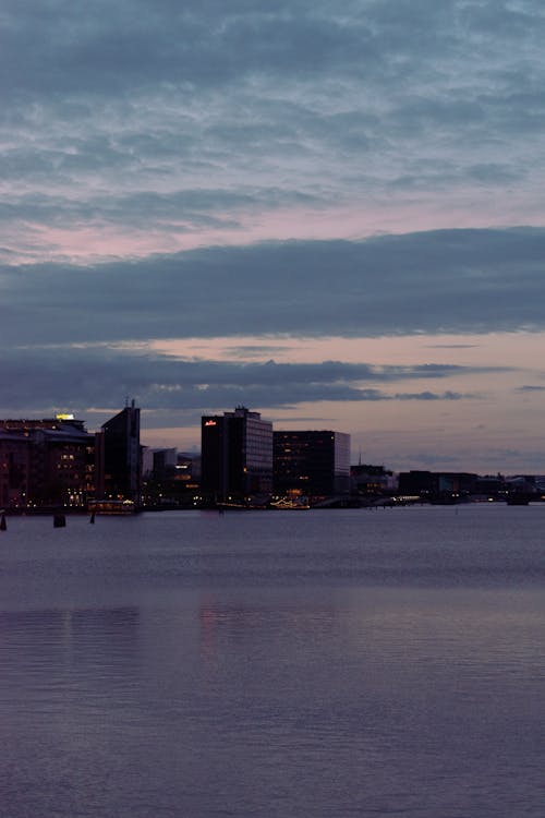 View of Modern, Waterfront Buildings in City at Sunset