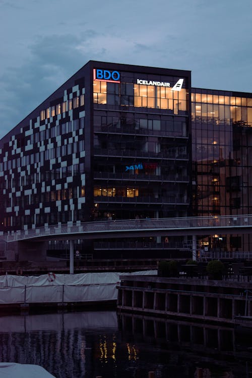 Facade of an Illuminated, Modern Office Building in City at Dusk 