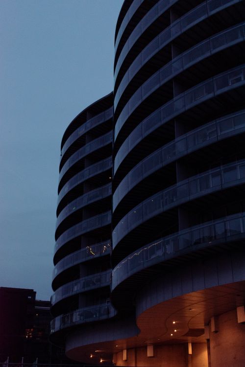 Free Capture of the Gemini Residence showcasing its iconic curved design at twilight. Stock Photo