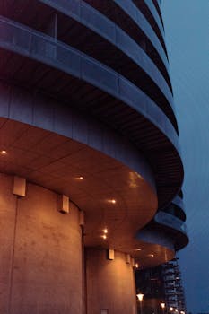 Illuminated modern architecture of Gemini Residence in Copenhagen at night.
