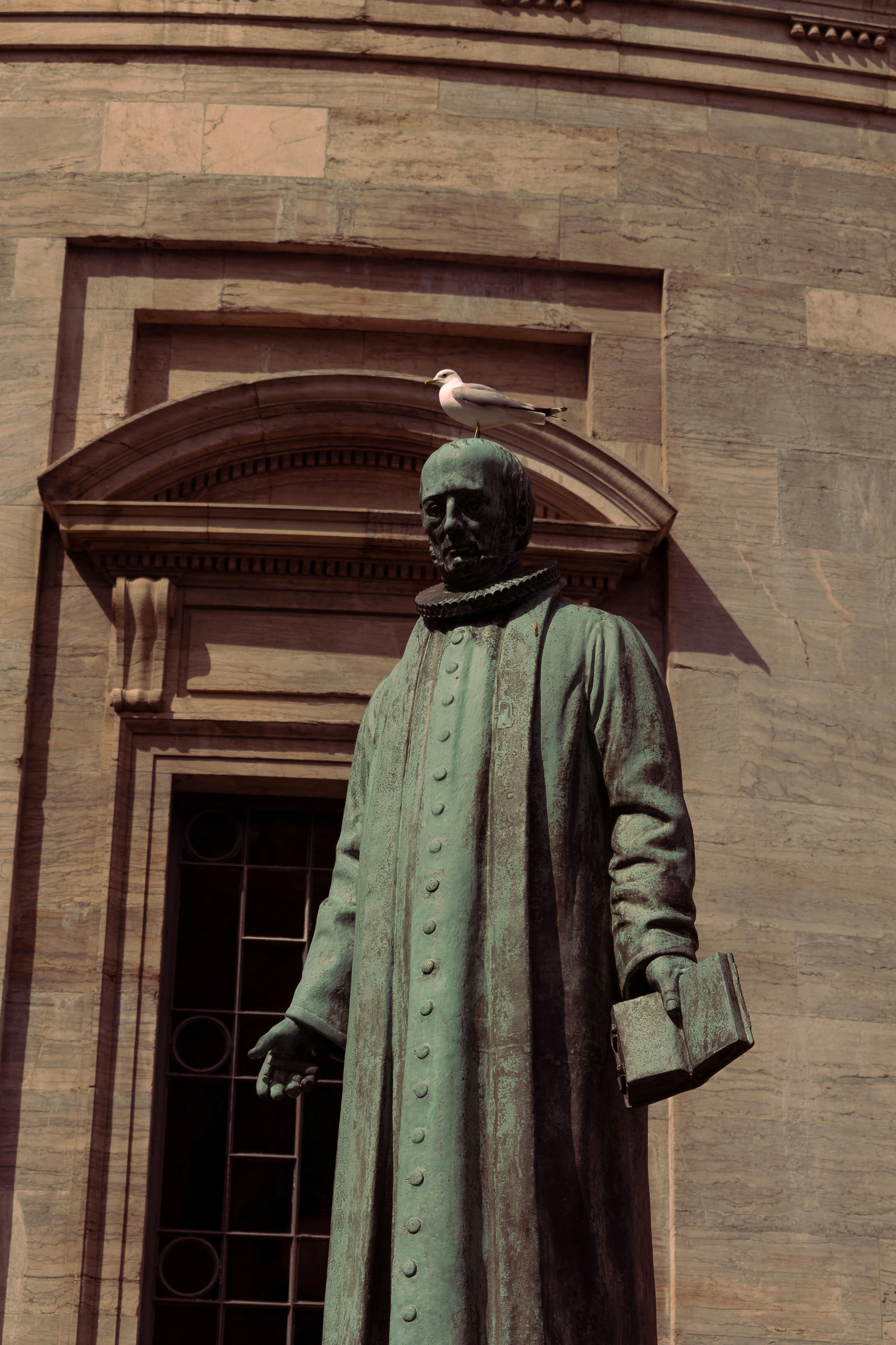 Bronze statue in front of Copenhagen's Marble Church, showcasing architectural detail.