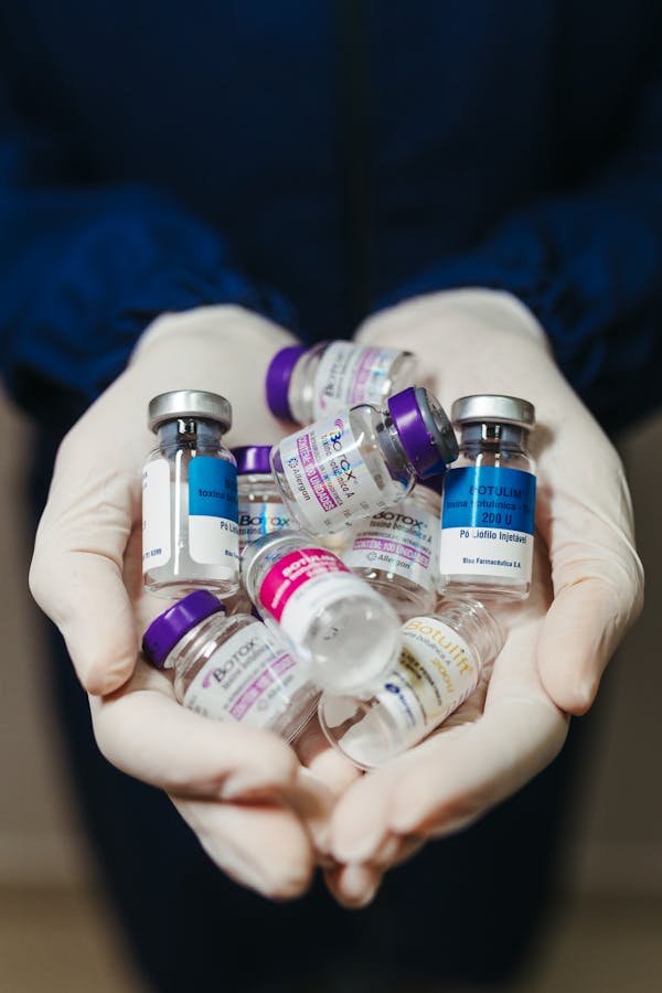  a person holding several empty bottles of Botox 