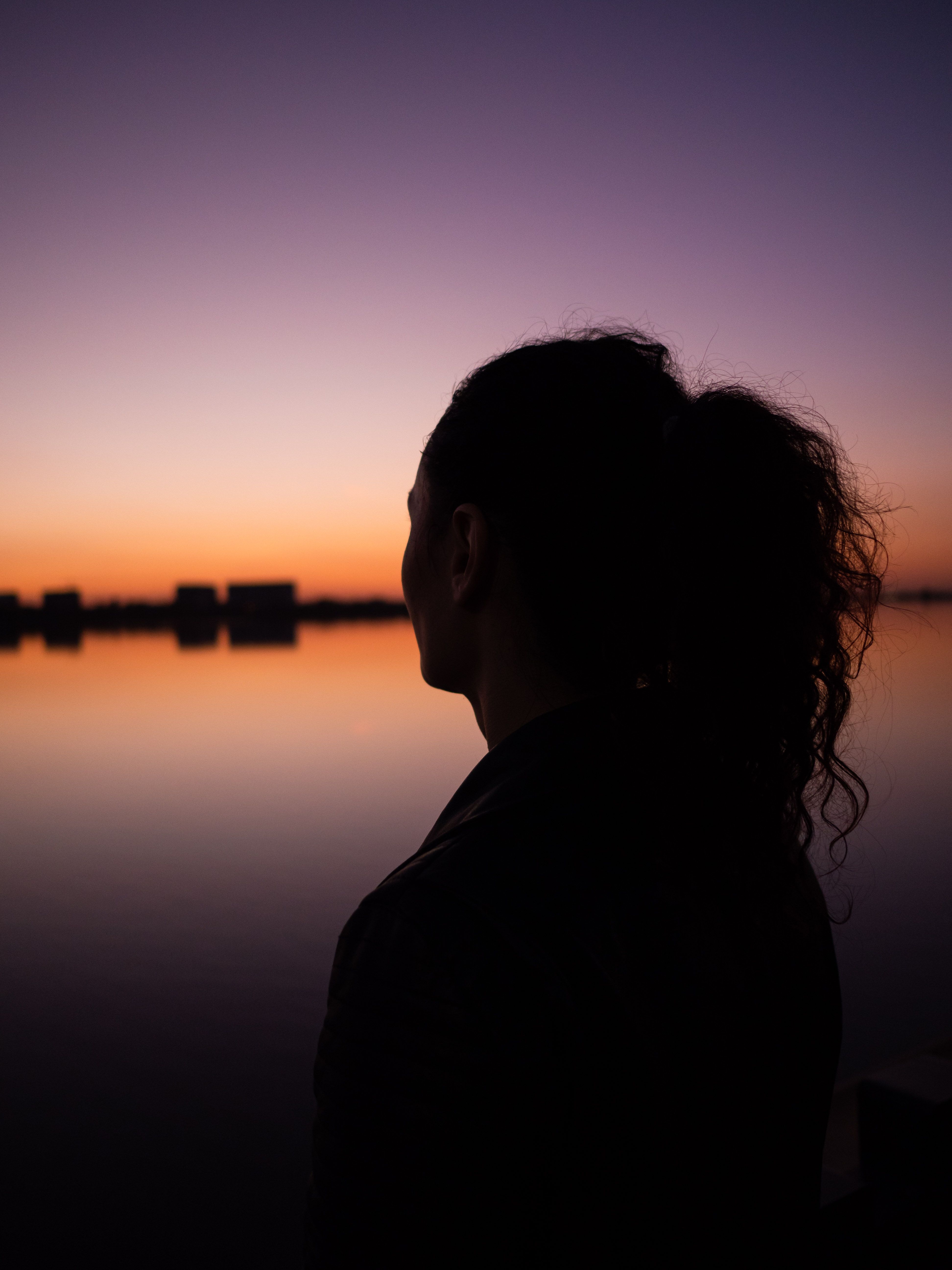 Silhouette of Woman at Sunset by Lake · Free Stock Photo