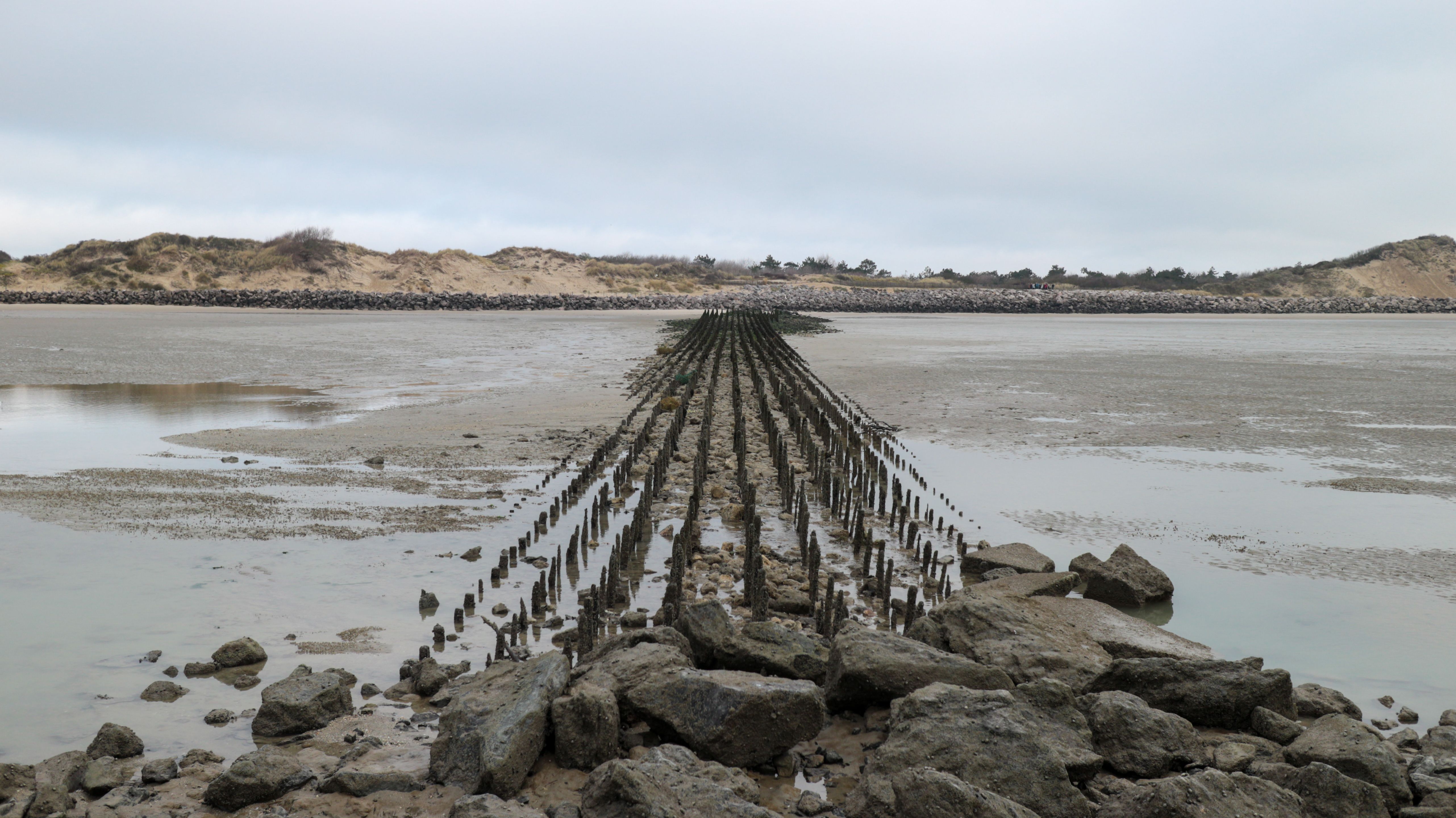 Serene view of a breakwater along Berck's coast, capturing an overcast day.