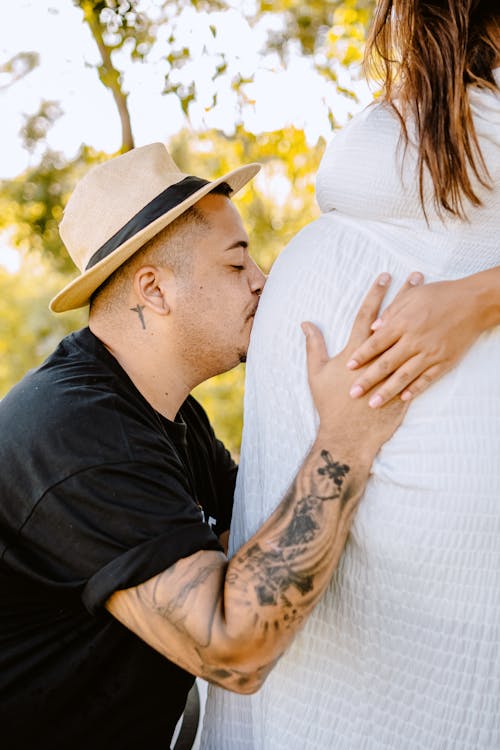 Photo of a Man Kissing the Belly of a Pregnant Woman