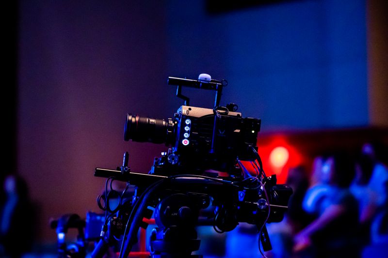 A high-quality camera setup capturing a live studio event with an audience in the background.