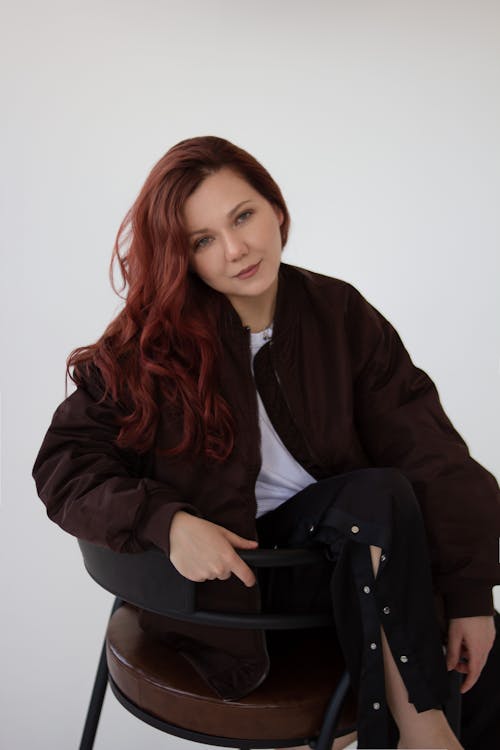 Photo of a Redhead Woman Sitting in the Studio